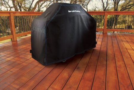 Broil King Grill Cover 68487 sitting on a wood patio